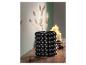 Un vase noir avec des billes et des herbes séchées
