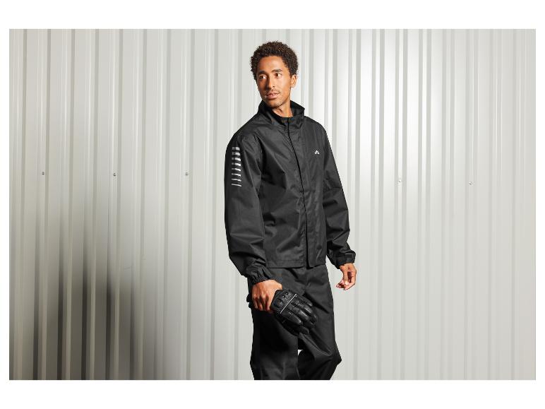 Un homme portant une veste, un pantalon et des gants noirs.