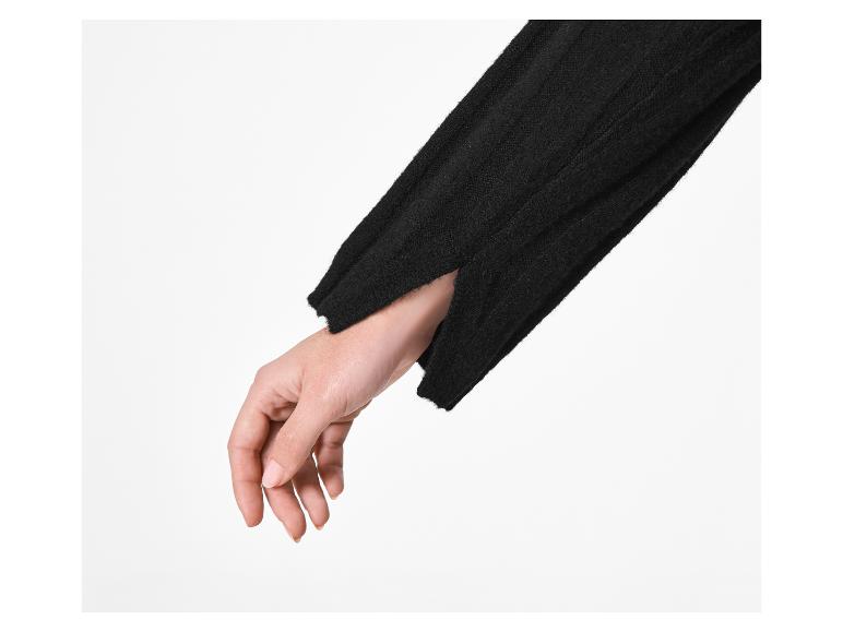 Main d'une personne dans une manche de pull noir avec une ouverture au poignet.