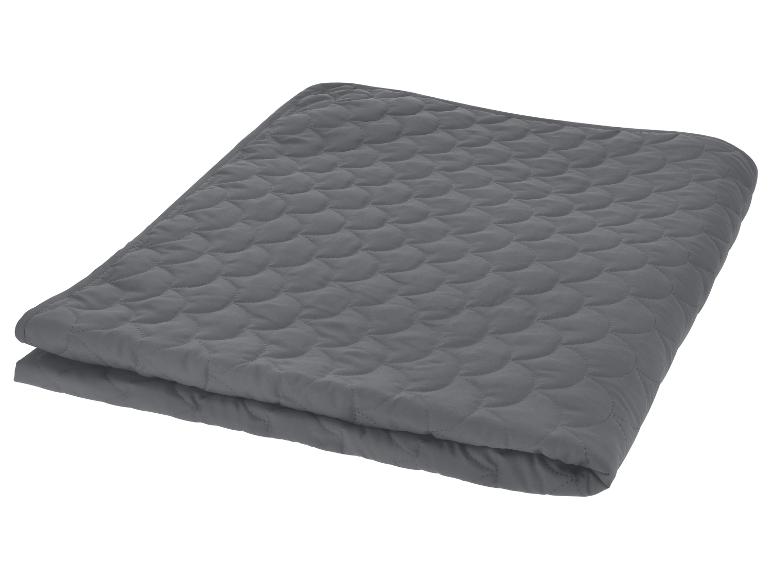 Couverture matelassée grise pliée en deux.