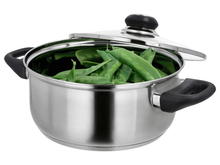Casserole en acier inoxydable avec couvercle, remplie de cosses de pois verts frais.