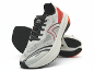 Paire de chaussures de sport blanches et rouges avec lacets et semelles noirs, l'une debout.