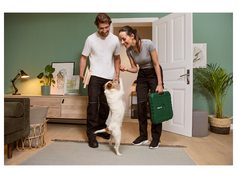 Couple heureux avec leur chien et une boîte à outils Parkside.