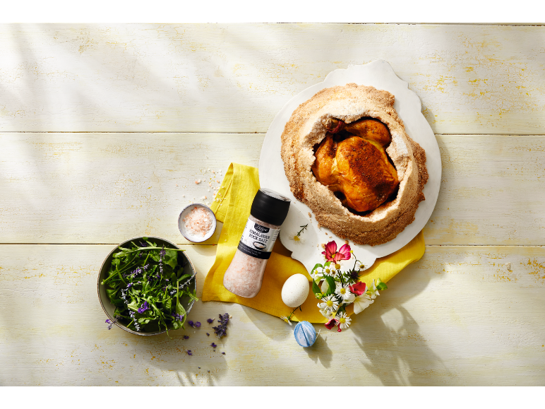 Poulet rôti en croûte de sel avec salade verte, sel de l'Himalaya et décorations de Pâques.