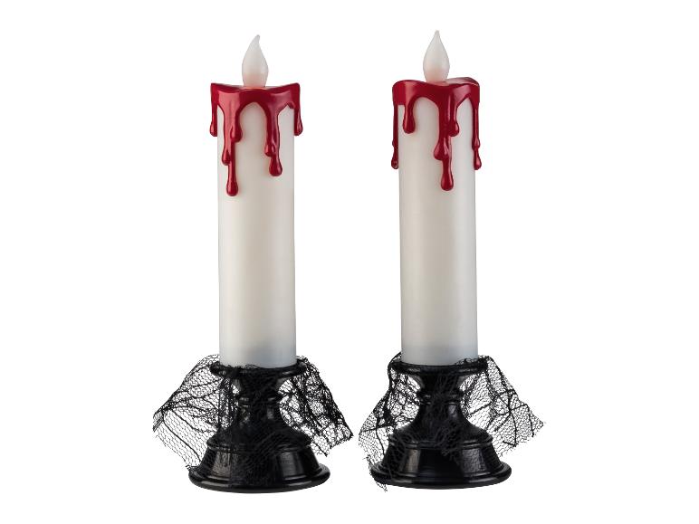 Deux bougies d'Halloween avec des gouttes de cire rouge et des toiles d'araignée noires à la base.