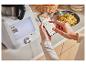 Une femme utilise une application pour cuisiner avec un robot culinaire Monsieur Cuisine.