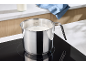 Lait dans une casserole en acier inoxydable sur une plaque de cuisson dans la cuisine.