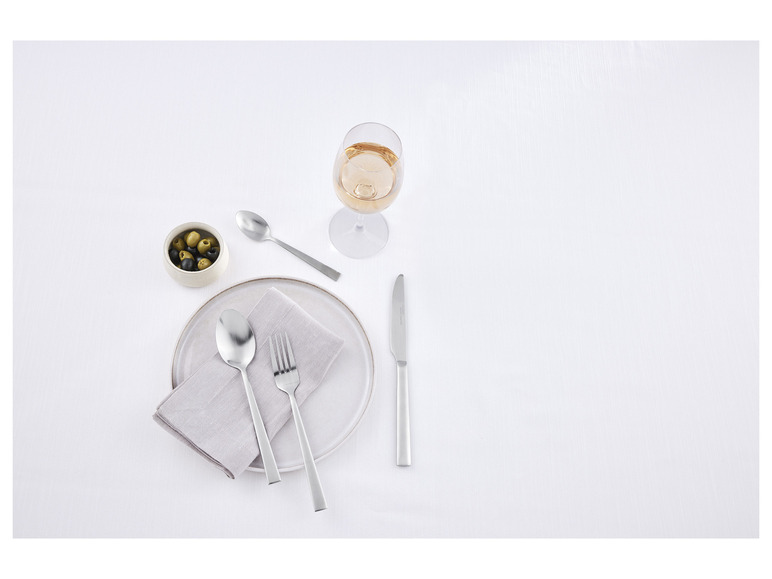 Un couvert avec un couteau, une fourchette et une cuillère sur une assiette.