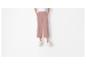 Culottes amples rose poudré et baskets blanches.