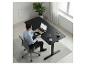 Homme travaillant à un bureau noir avec un ordinateur portable, dans un bureau moderne.