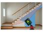 Niveau laser vert projetant des lignes sur un escalier intérieur.