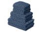 Pile de serviettes de bain bleues texturées de différentes tailles.