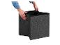 Mains tenant une boîte de rangement pliable gris foncé, prête à l'emploi.
