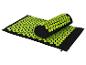 Tapis et oreiller d'acupression noirs avec des picots verts.