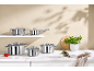 Ensemble de casseroles et poêles en acier inoxydable dans une cuisine avec des ingrédients frais.