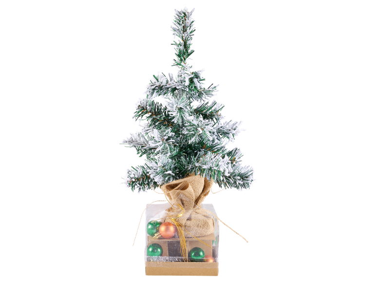 Petit sapin de Noël enneigé dans une boîte décorative avec des boules.