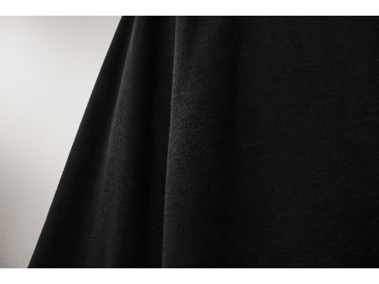 Gros plan sur un tissu en maille noir et doux avec des plis élégants.
