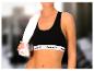 Une femme portant un soutien-gorge de sport Reebok noir avec une serviette sur l'épaule.
