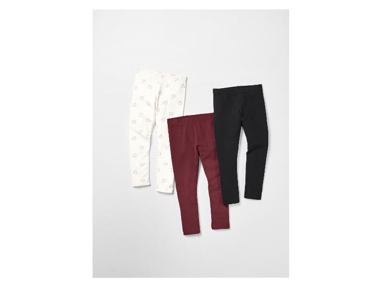 Trois leggings pour filles : un avec imprimé cœurs, un bordeaux et un noir.