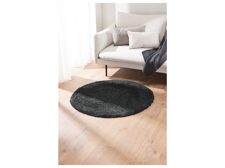 Un tapis rond gris sur un sol en bois