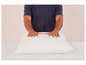 Les mains d'un homme sur un oreiller blanc.