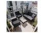 Ensemble de mobilier de balcon 4 pièces en rotin noir avec coussins gris et table en verre.