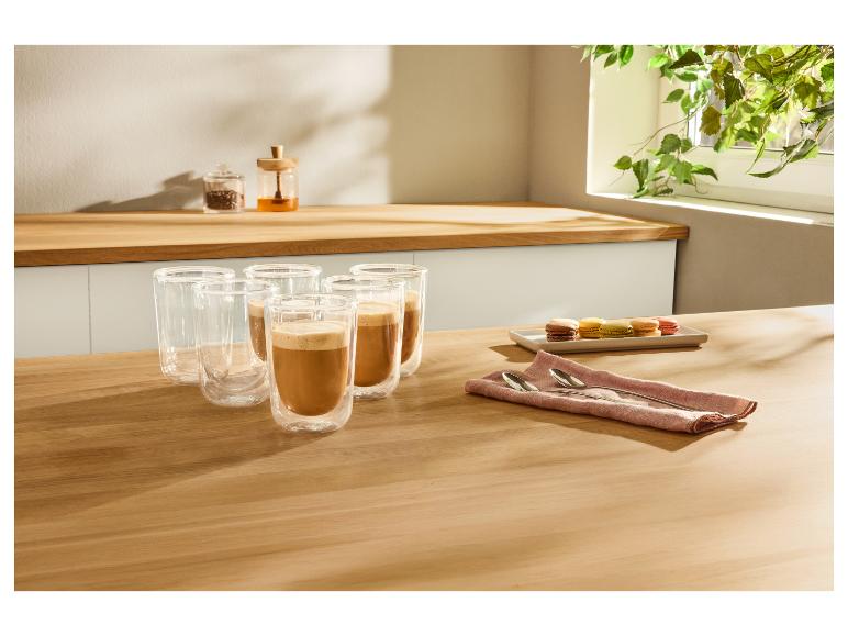 Tasses à café avec café et macarons sur une table en bois dans la cuisine.