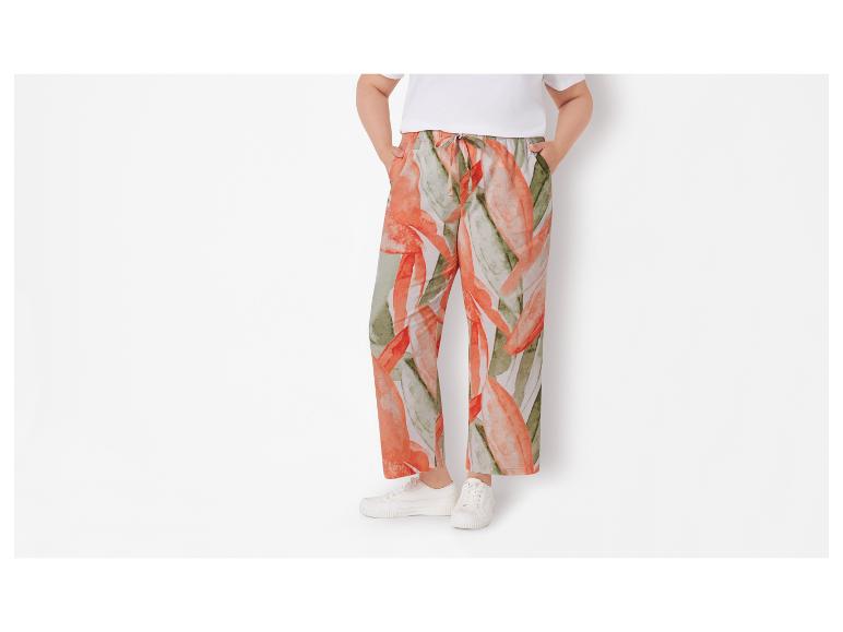 Pantalon fluide à motif floral et baskets blanches.