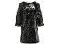 Une robe courte noire à manches longues, recouverte de paillettes.