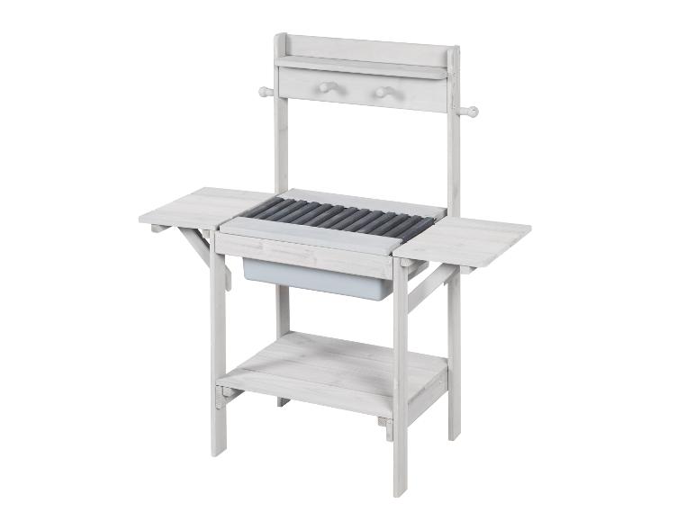 Table de jardin en bois blanc avec évier et étagères.