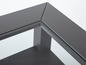 Une table basse gris foncé avec un plateau en verre.