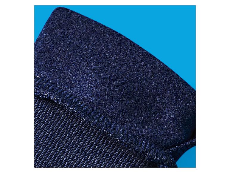 Gros plan de tissu bleu foncé avec une surface texturée, légèrement duveteuse et des coutures visibles