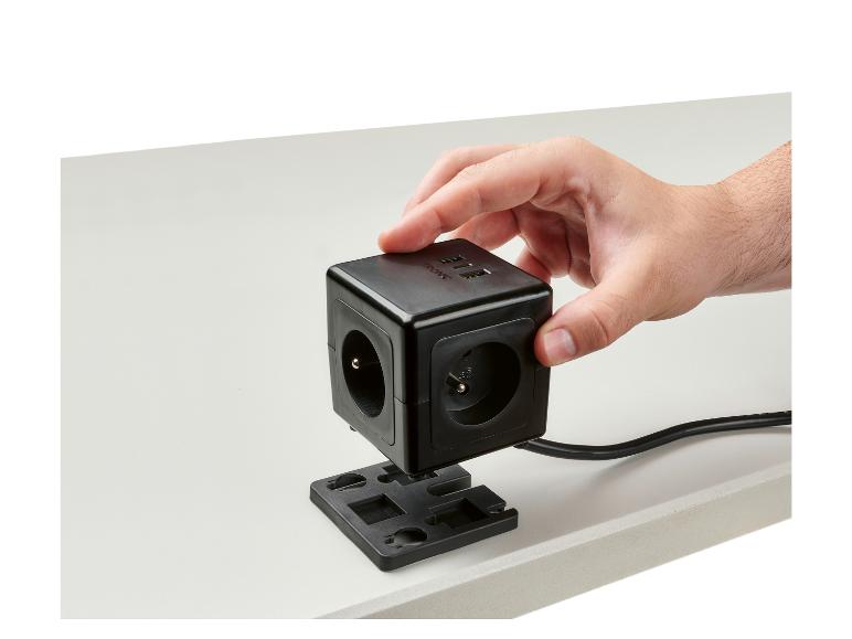 Une prise de courant noire avec des ports USB, fixée à un bureau.