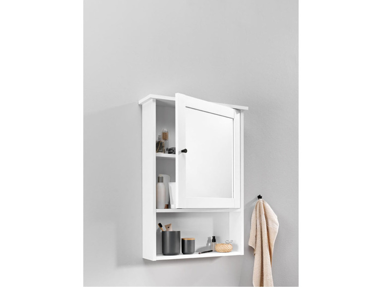 Armoire de salle de bain blanche avec porte miroir et accessoires.