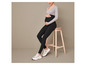Une femme enceinte portant un legging noir et des baskets blanches.
