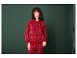 Femme portant un sweat-shirt rouge et un pantalon de jogging à motifs de flocons de neige.
