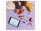 Un enfant construit avec des blocs Lego Minecraft et utilise une tablette.