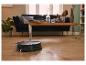 Un robot aspirateur sur un sol en bois dans un salon.