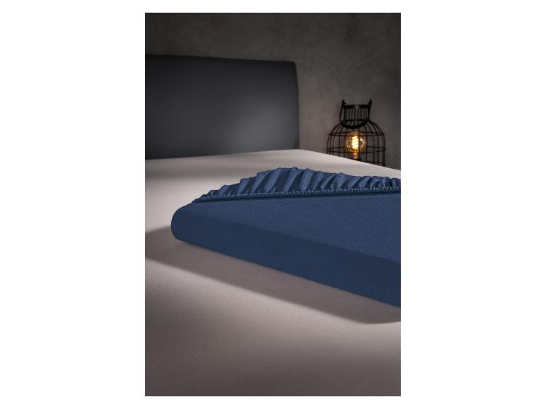 Drap-housse bleu marine sur un lit.