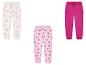 Trois joggings pour filles : un imprimé nœuds, un imprimé cœurs, un rose uni.