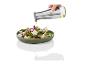 Un bol vert avec une salade de feta, d'olives vertes et d'oignons rouges, arrosée d'huile d'une bouteille.