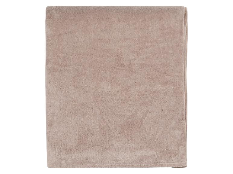 Couverture douce et pliée de couleur beige.