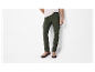 Pantalon cargo vert foncé et chaussures beiges.