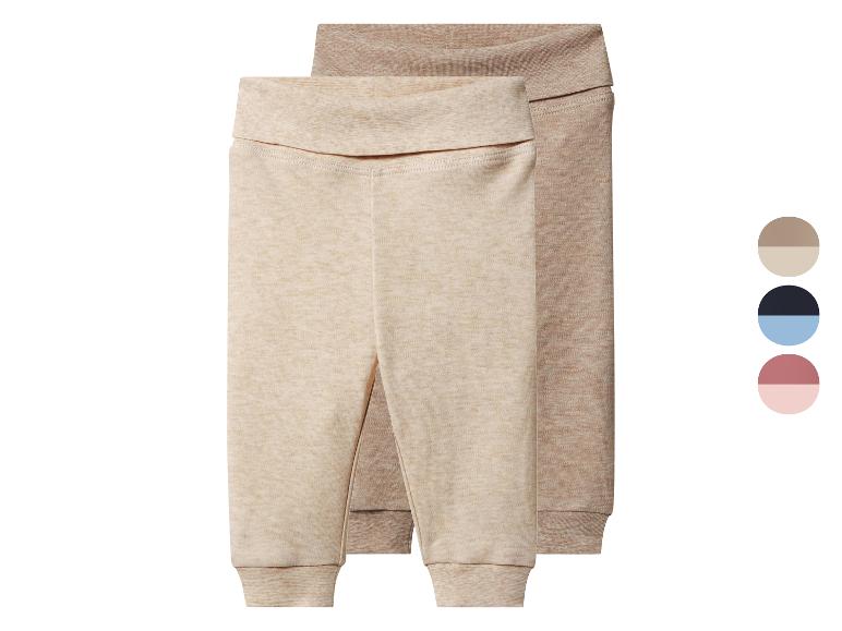 Deux pantalons de bébé beiges et marron clair avec poignets et taille repliable.