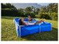 Couple se relaxant dans une piscine hors sol bleue dans un jardin ensoleillé.