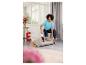 Femme nettoyant un panier pour chien avec un aspirateur à main dans un salon lumineux.