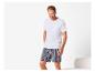 Homme en t-shirt blanc et short rayé, souriant.