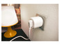 Une prise intelligente blanche branchée sur une prise murale, connectée à une lampe de table jaune.