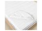 Protège-matelas blanc avec élastiques sur un matelas dans un lit en bois.