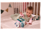 Bébé explore un cube d'activités en tissu avec un lapin et un ours.